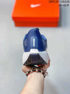 Rear view of the sneaker showing the navy heel, white midsole and black outsole segment.