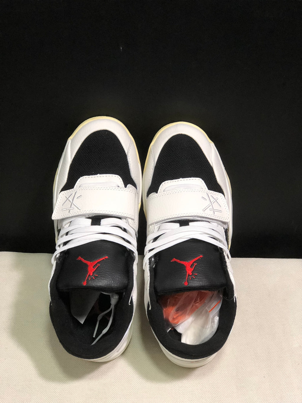 Top view showing black toe panels, white laces, forefoot straps, and red tongue branding.