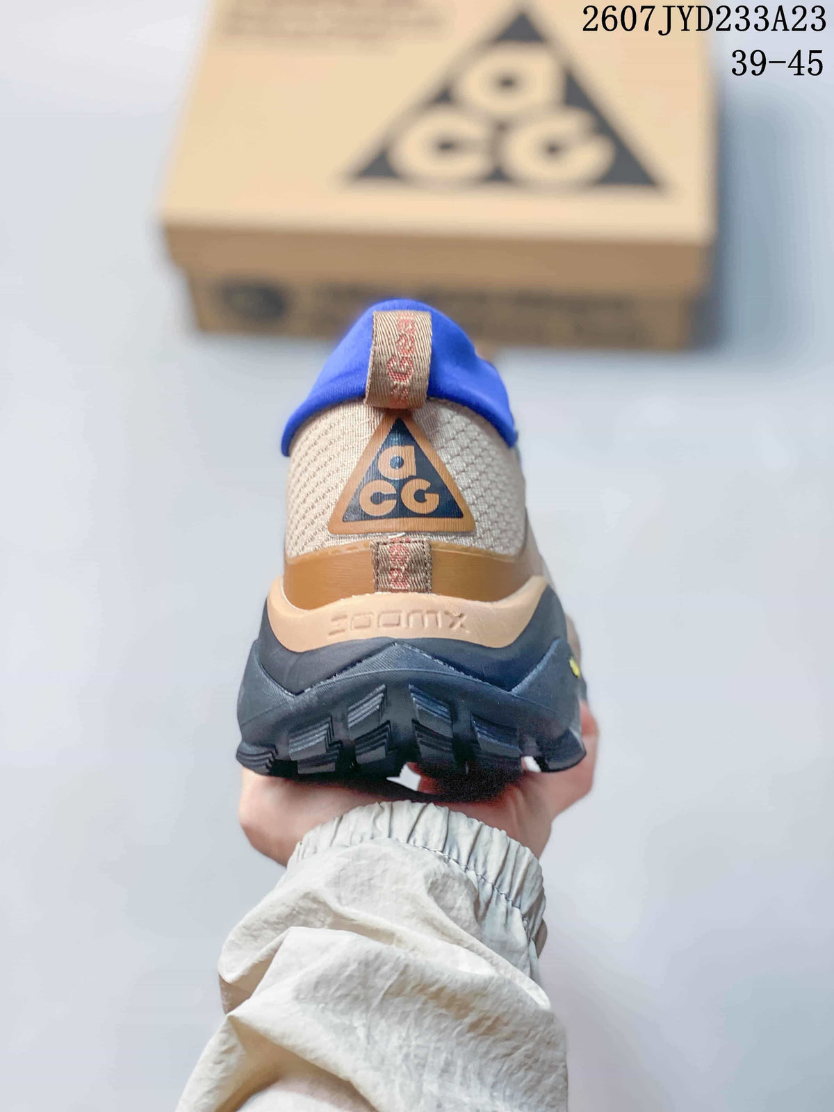 Rear view showing the blue padded collar, ACG heel branding, layered heel structure, and black outsole.