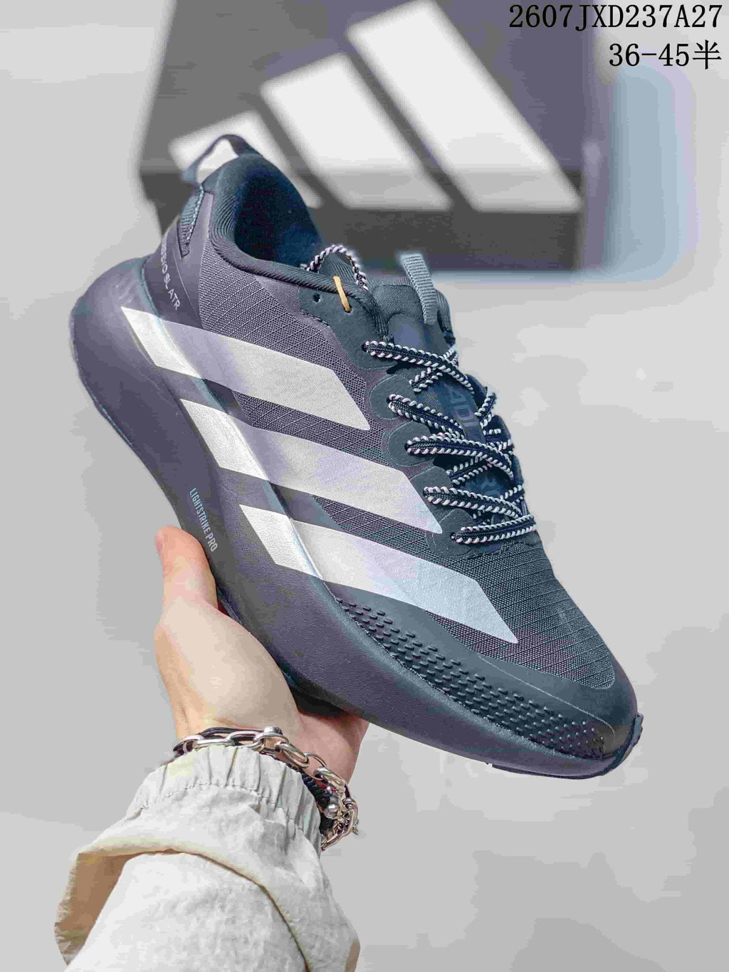 Angled side view of the dark gray sneaker showing the silver side stripes, mesh upper, and Lightstrike Pro marking.