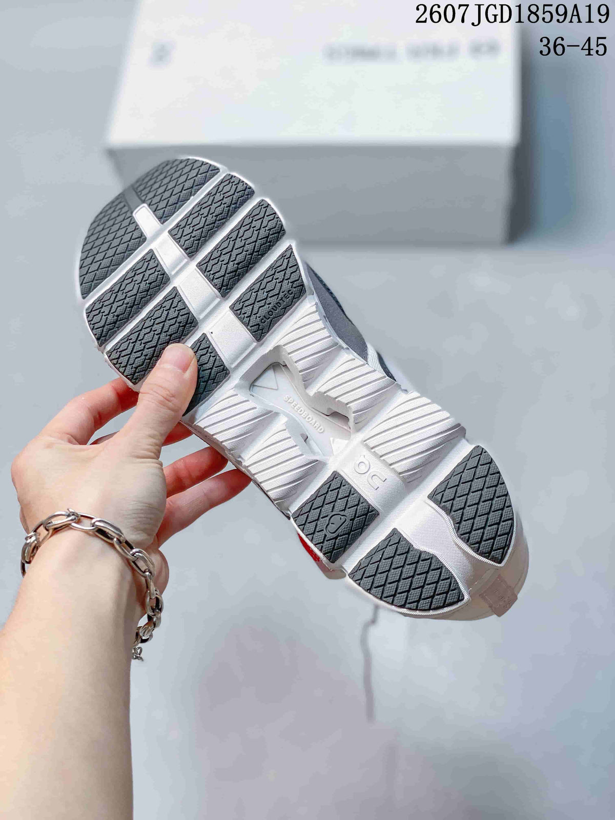 Underside view of an On sneaker showing the segmented outsole and textured dark rubber sections.