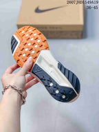 Underside view showing the orange and dark gray patterned rubber outsole of the sneaker.