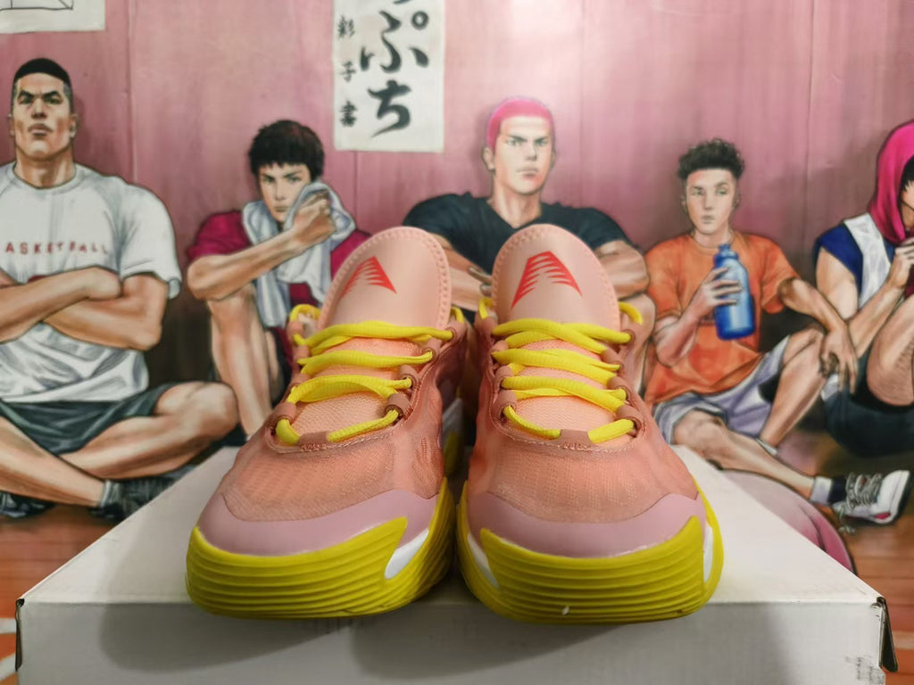 Front view of pink basketball sneakers with yellow laces and yellow outsoles