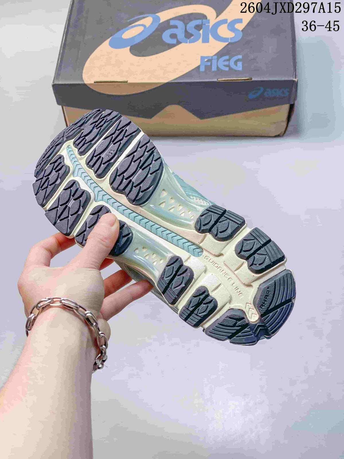 Outsole view of the ASICS sneaker, showing dark tread sections and a segmented sole