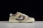 Side profile showing the beige and brown upper, contrasting Swoosh, white midsole, and light green outsole.