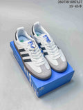 Pair of white adidas Originals Samba sneakers with black stripes, gray toe panels and a blue adidas shoebox; source text shows style code 2607ND1087A27 and size range 35–45.5.