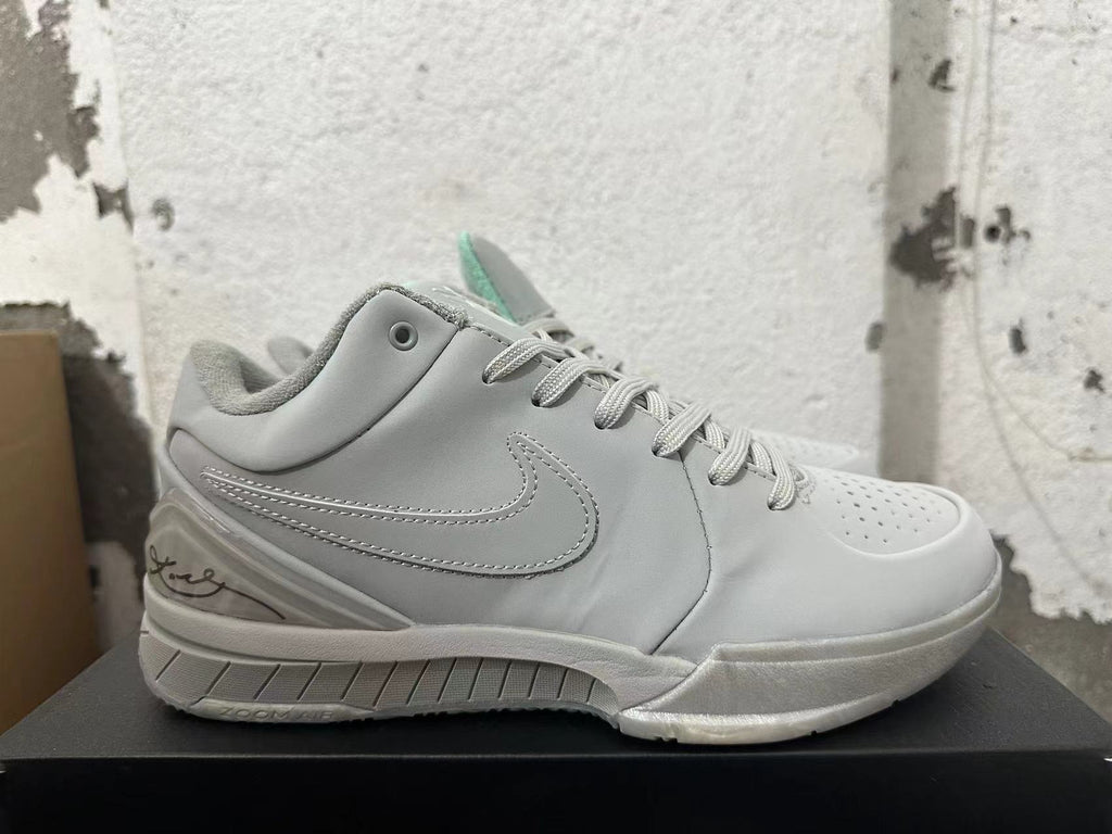 Side view of a light grey basketball shoe with a Swoosh, lace-up closure, and Kobe-inspired signature detail.