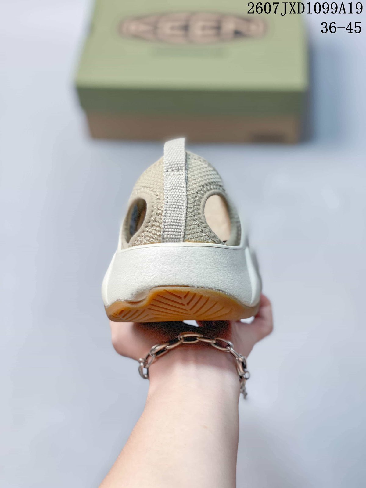 Rear view of the sandal showing the open heel area, heel strap, and layered outsole.