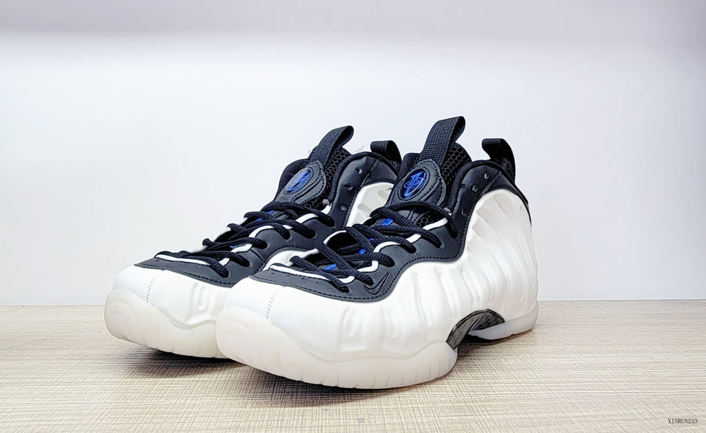Pair of white, black and blue Nike Air Foamposite One high-top sneakers, front three-quarter view
