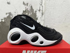 Side view of a black sneaker with a white Swoosh and sculpted white midsole.
