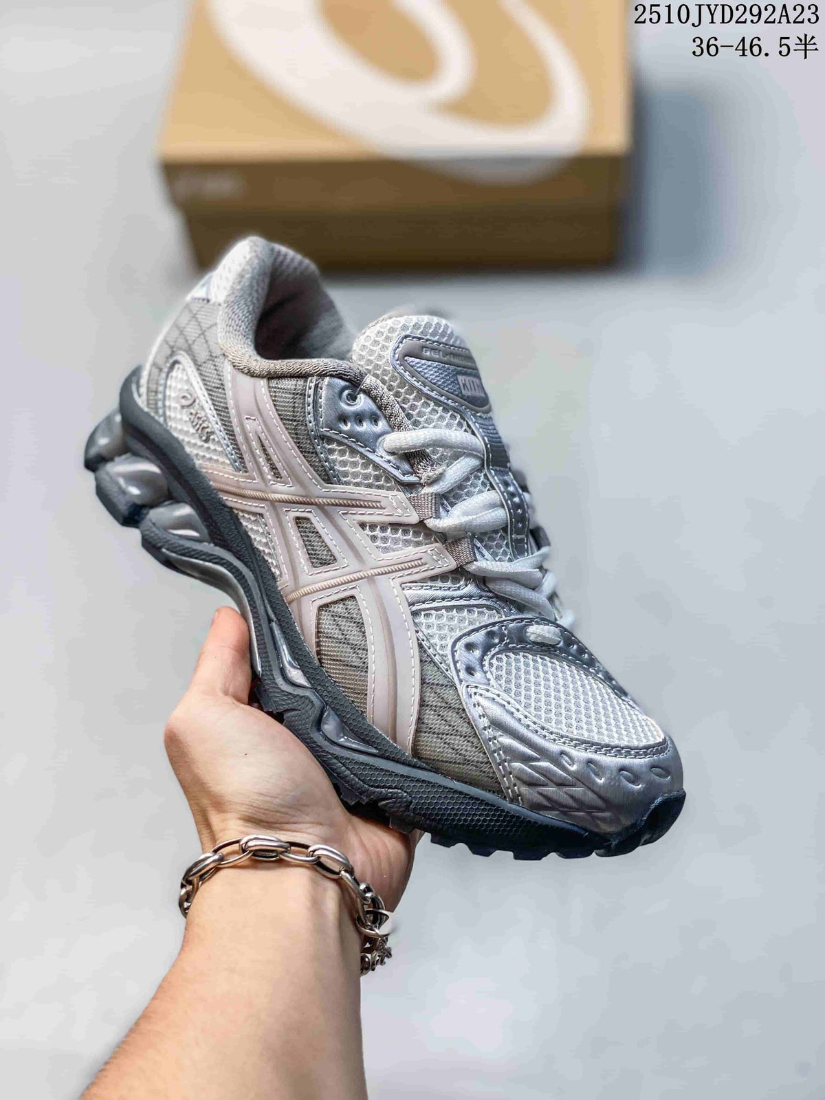 Close-up of a silver and gray sneaker with pale pink accents and a sculpted sole.
