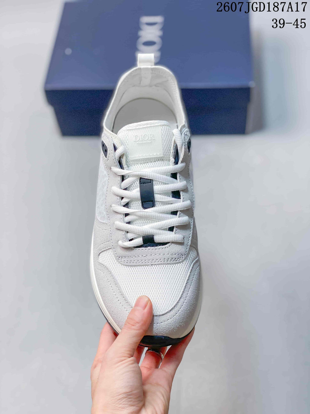Front view showing the white laces, contrasting dark lace details, tongue branding, and textured toe panel.