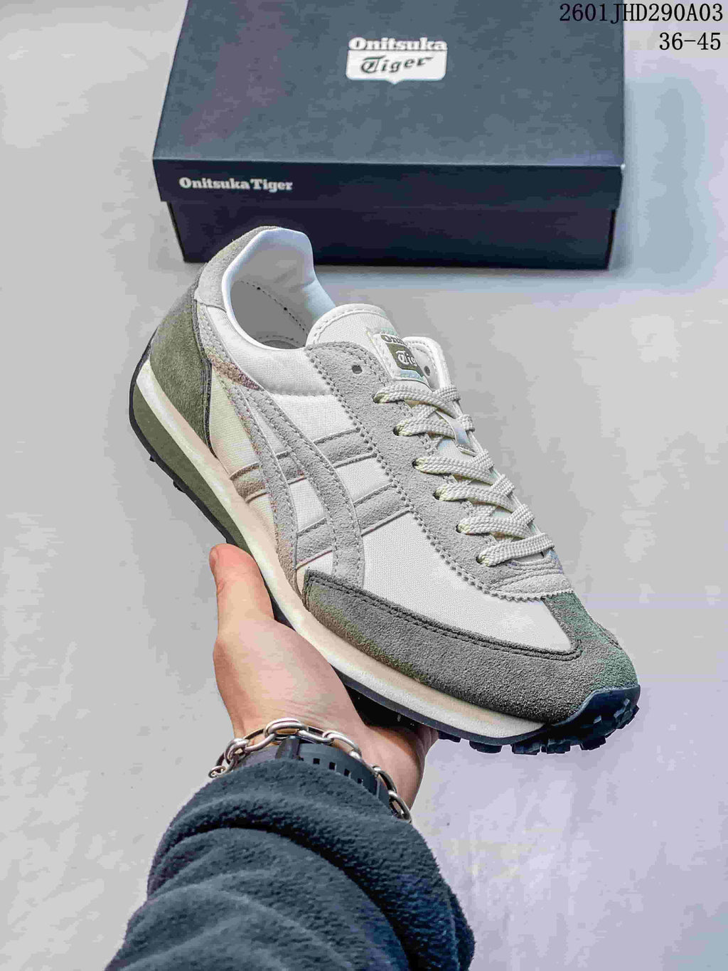 Three-quarter view of the off-white and gray-green Onitsuka Tiger EDR 78 sneaker held in front of its box.