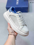 Close-up side view of a white Dior sneaker with blue collar trim, woven side panel, white laces, and thick white outsole; overlay shows style code 2607GDD605A15 and size range 39–44.