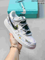 Angled view of a white low-top sneaker with multicolor graphics and gray-and-dark laces