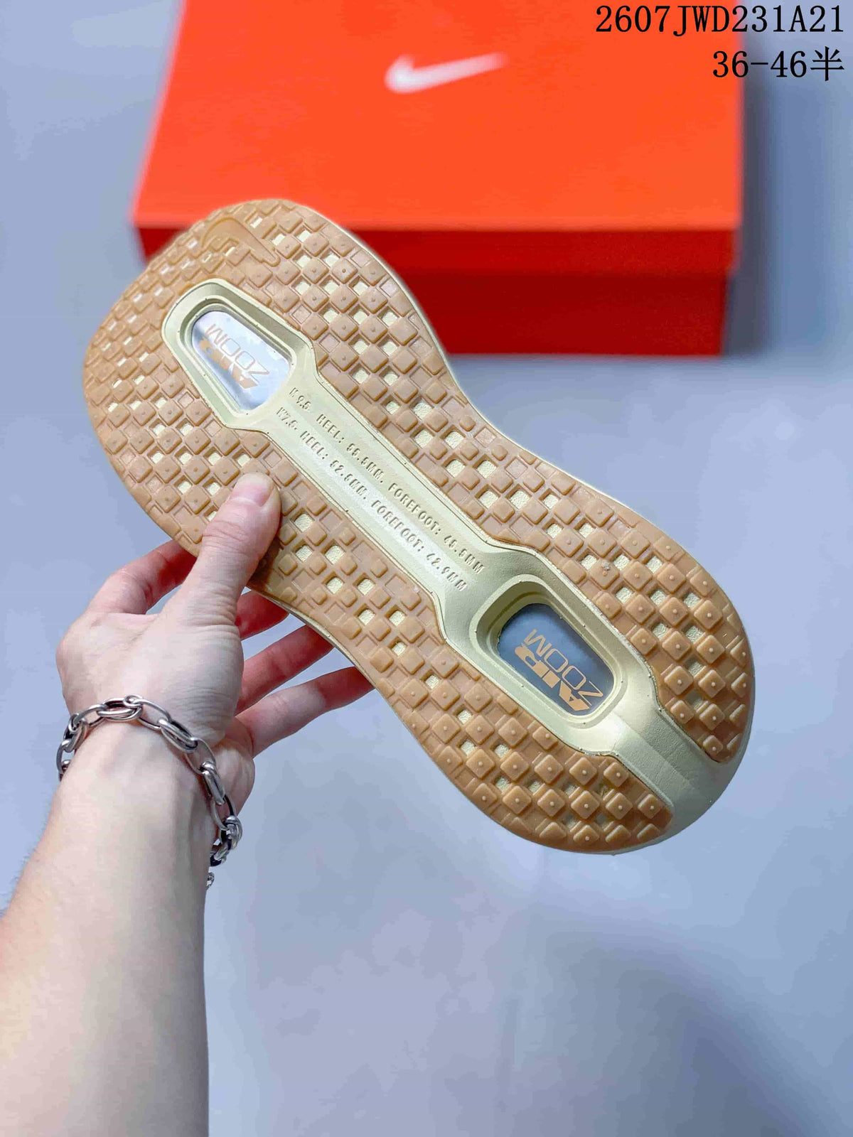 Underside view showing the sneakers' gum-colored patterned outsole and visible cushioning windows.