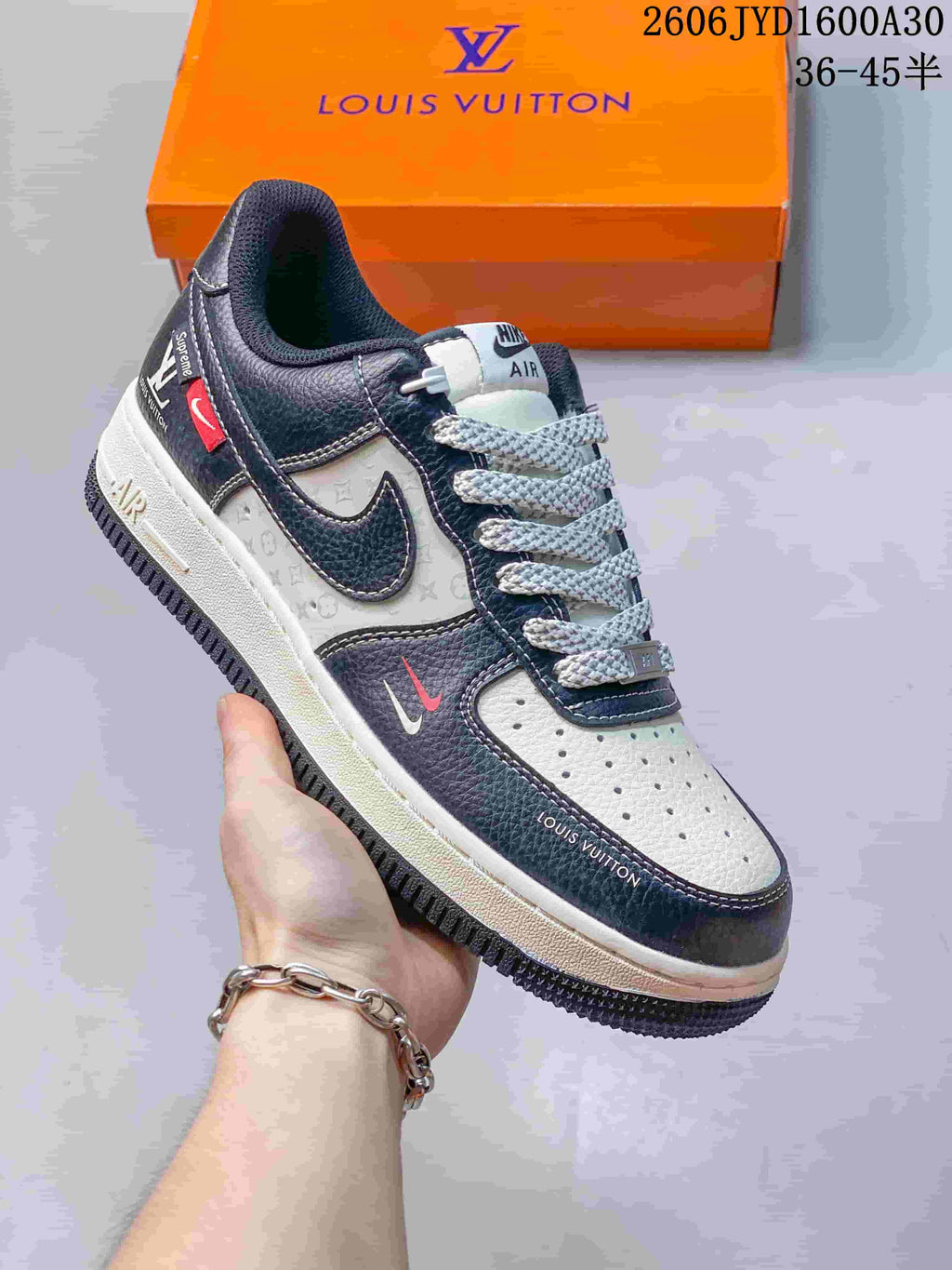 Angled side view of the navy and white sneaker with patterned panels and small red accents