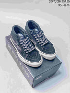Pair of black Vans sneakers with patterned laces displayed on a branded shoe box.