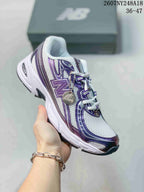 Angled side view of the white and purple New Balance 740 sneaker with visible branding and attached decorative tag.