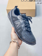 Side view of a charcoal lace-up sneaker showing its layered upper and low-profile sole; overlay shows style code 2607JWD101A01 and size range 39–45.