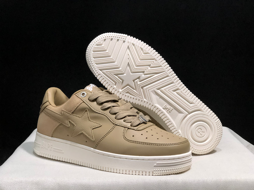 Angled view of the beige sneakers with one shoe lifted to reveal the patterned white outsole.