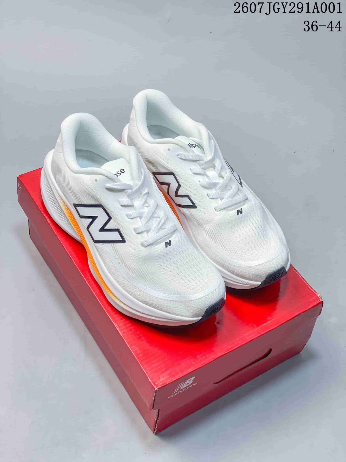 White New Balance running shoes with dark logos and orange accents, shown on a red shoebox.