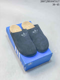 Black adidas Adimule mule slides displayed on a blue shoebox, with the stated size range visible at the top.