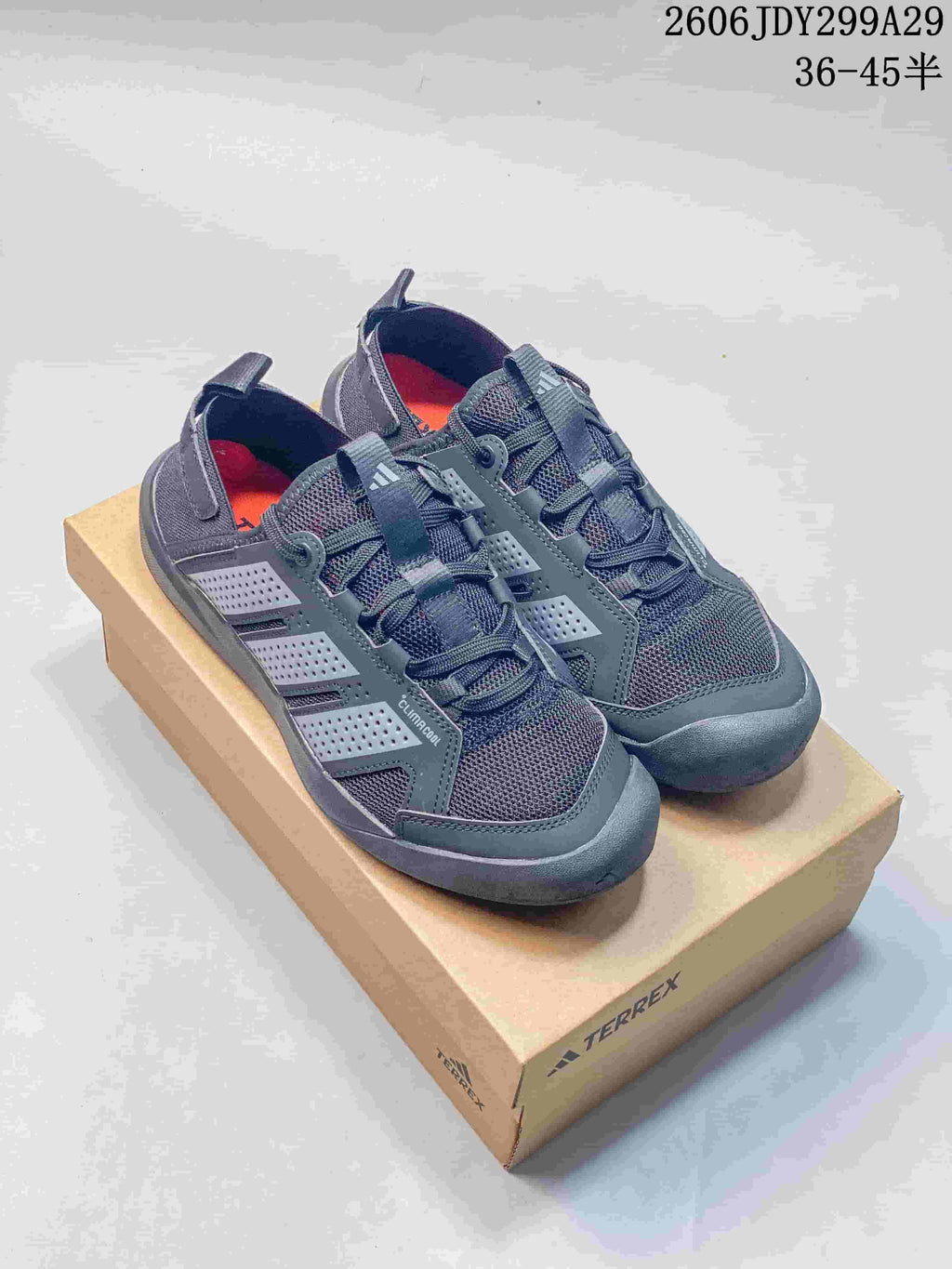 Pair of dark gray Adidas Terrex sneakers displayed on a Terrex shoe box, with the size range 36–45 shown in the upper right.