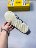 Close-up of the sneaker outsole showing a light cream diamond-patterned tread and branded outsole detail.