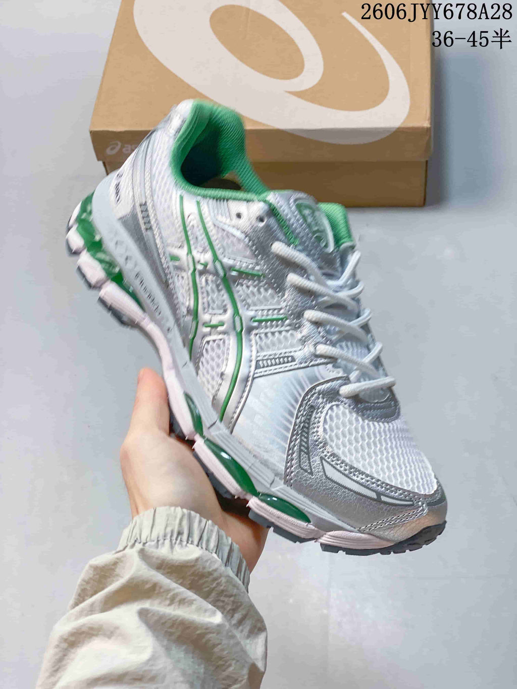 Angled side view of the shoe showing its silver-toned panels, green details, and sculpted sole.