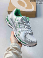 Angled side view of the shoe showing its silver-toned panels, green details, and sculpted sole.
