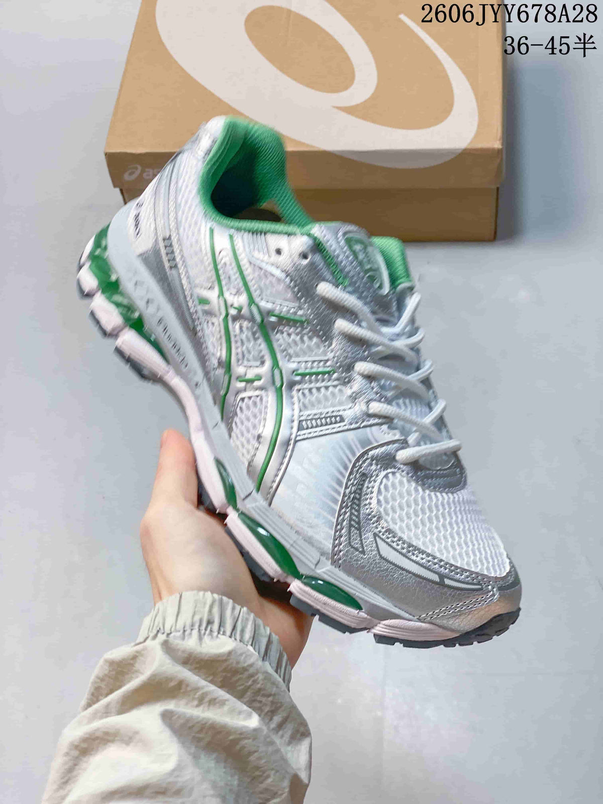 Angled side view of the shoe showing its silver-toned panels, green details, and sculpted sole.