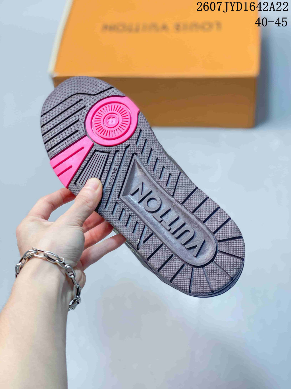 Close-up of the sneaker outsole showing a textured tread pattern, central branding, and pink accent sections; image text shows 2607 TYD1642A22 and 40–45.