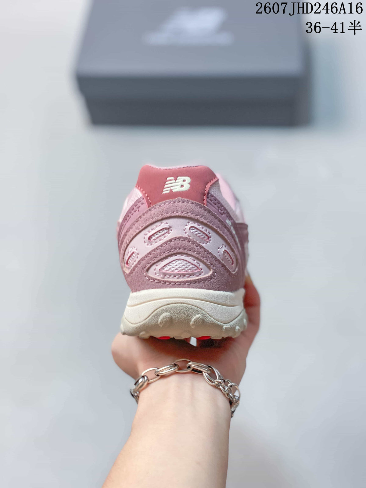 Rear view showing the padded pink heel collar, layered heel panels, and New Balance branding.