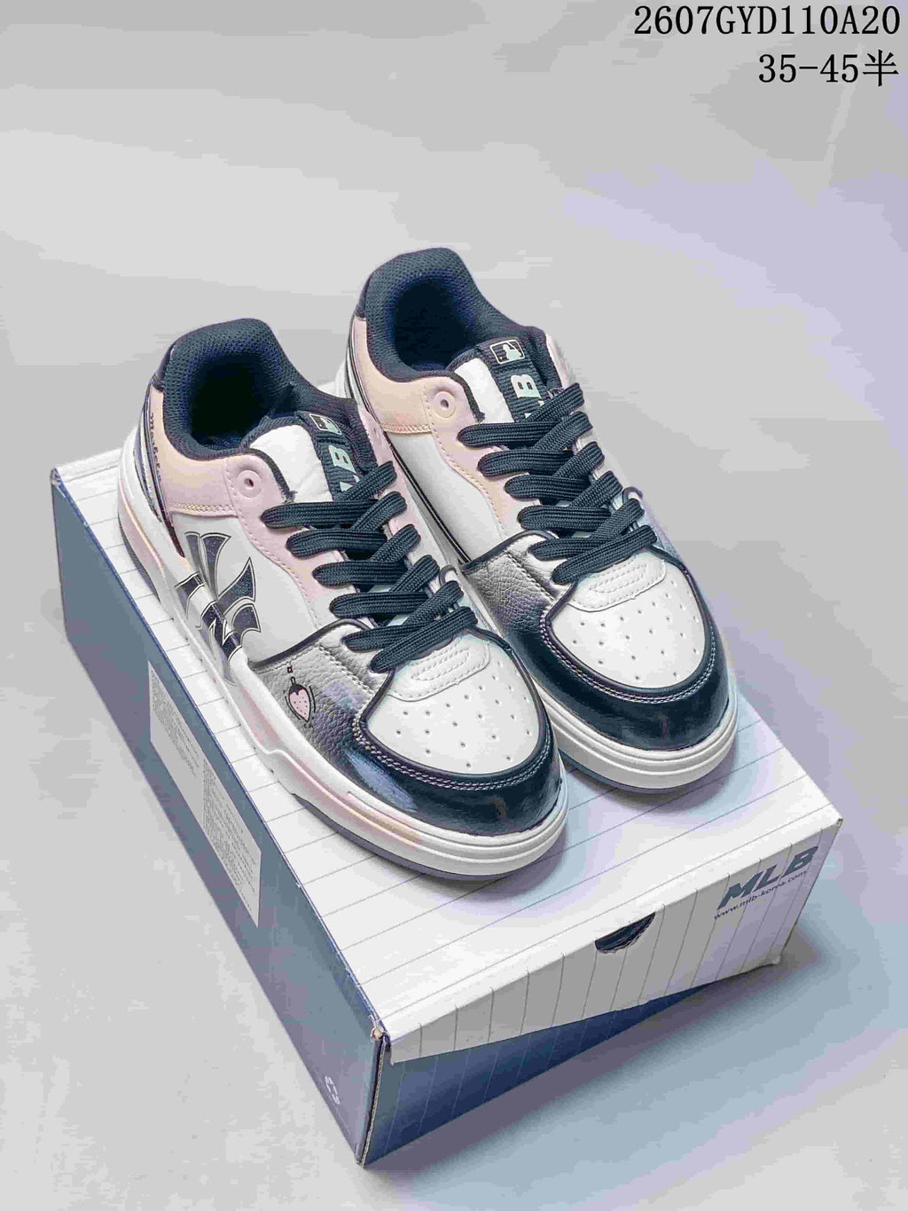 Pair of black, white, and pink MLB low-top sneakers displayed on an MLB shoe box.