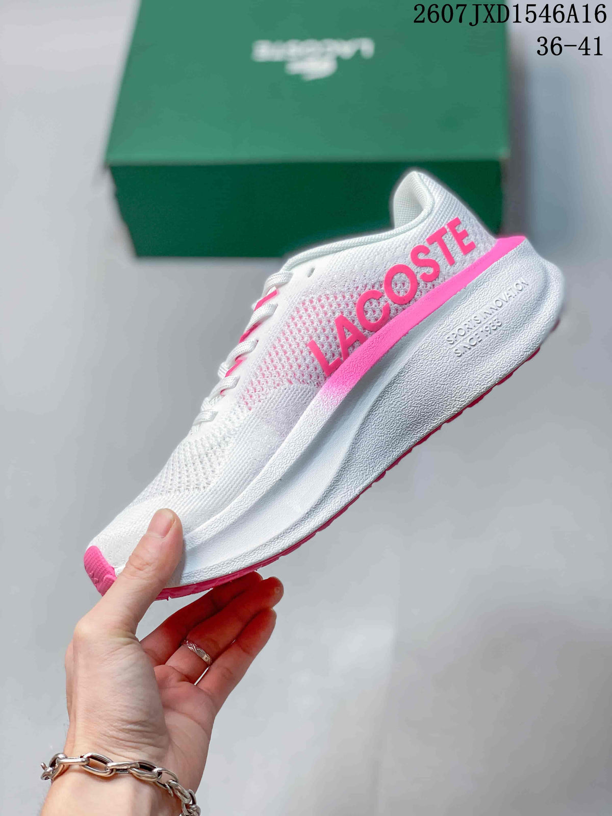 Side view showing the white textured upper, pink Lacoste branding, and sculpted sole.