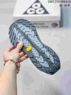 Close view of the lugged outsole with a textured gray and black tread pattern and yellow accent.