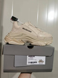 Beige Balenciaga Triple S sneaker displayed on its box, showing the side branding, chunky layered sole, and box label.