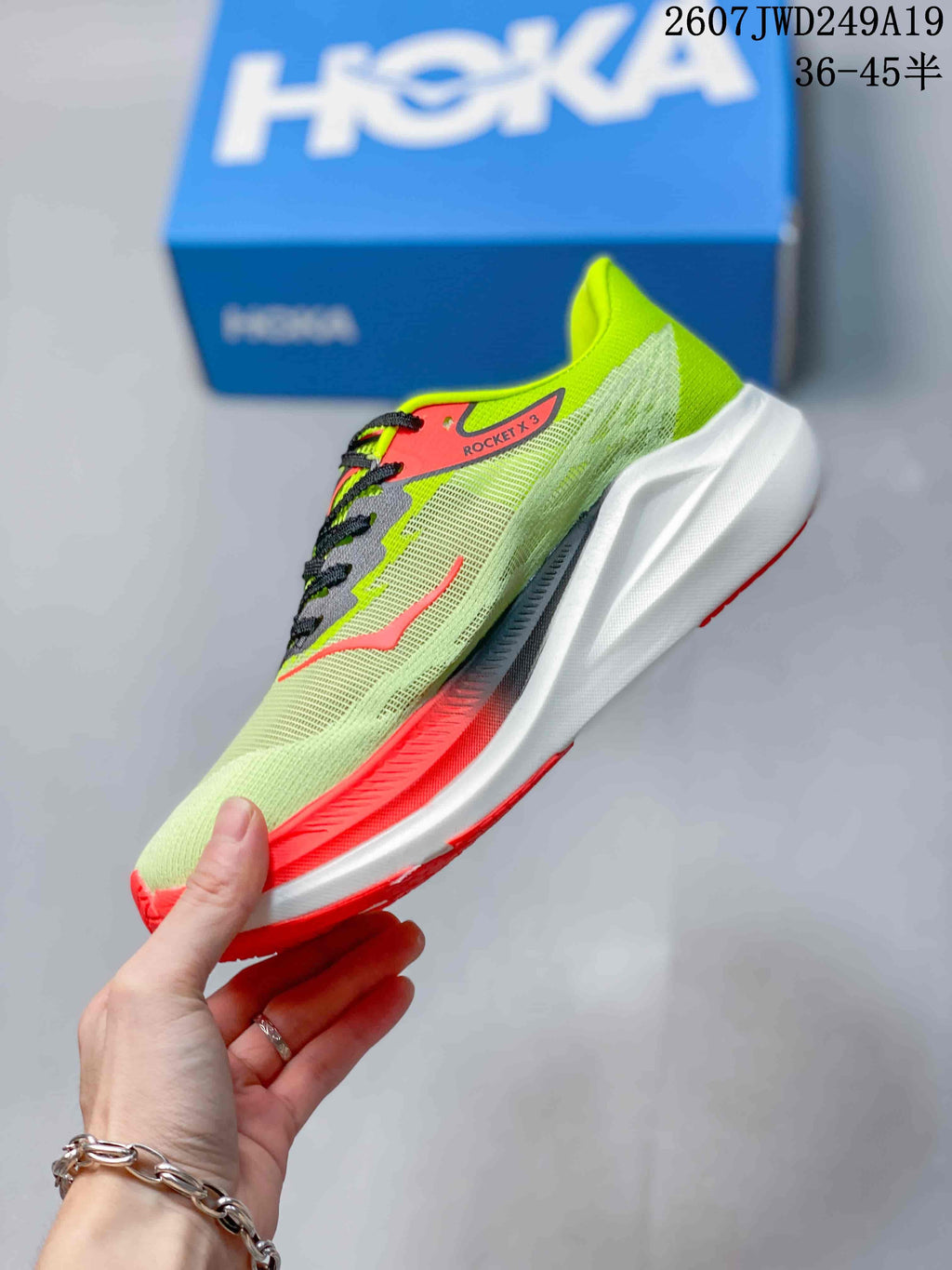 Side profile showing the mesh-like green upper, black laces, coral accents, and sculpted white midsole.