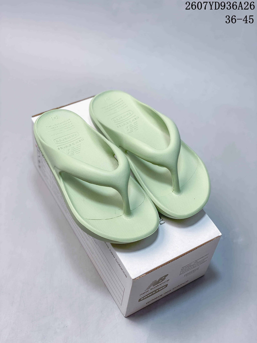 Pair of pale green New Balance thong sandals displayed on a branded shoe box; overlay text shows style code 2607YD936A26 and size range 36–45.