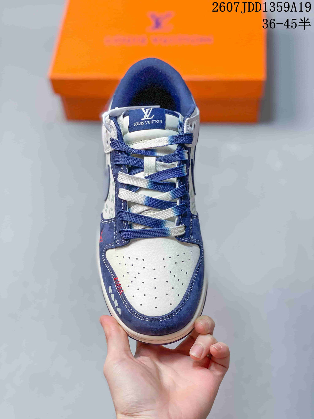 Top-down view of the sneaker showing white perforated toe material, navy overlays, and alternating navy and white laces.