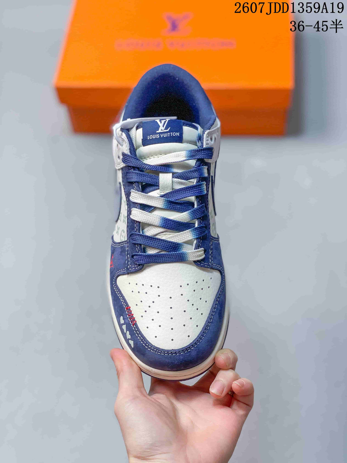 Top-down view of the sneaker showing white perforated toe material, navy overlays, and alternating navy and white laces.