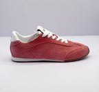 Lateral side view showing the pink textured upper, stitched panels and white midsole.