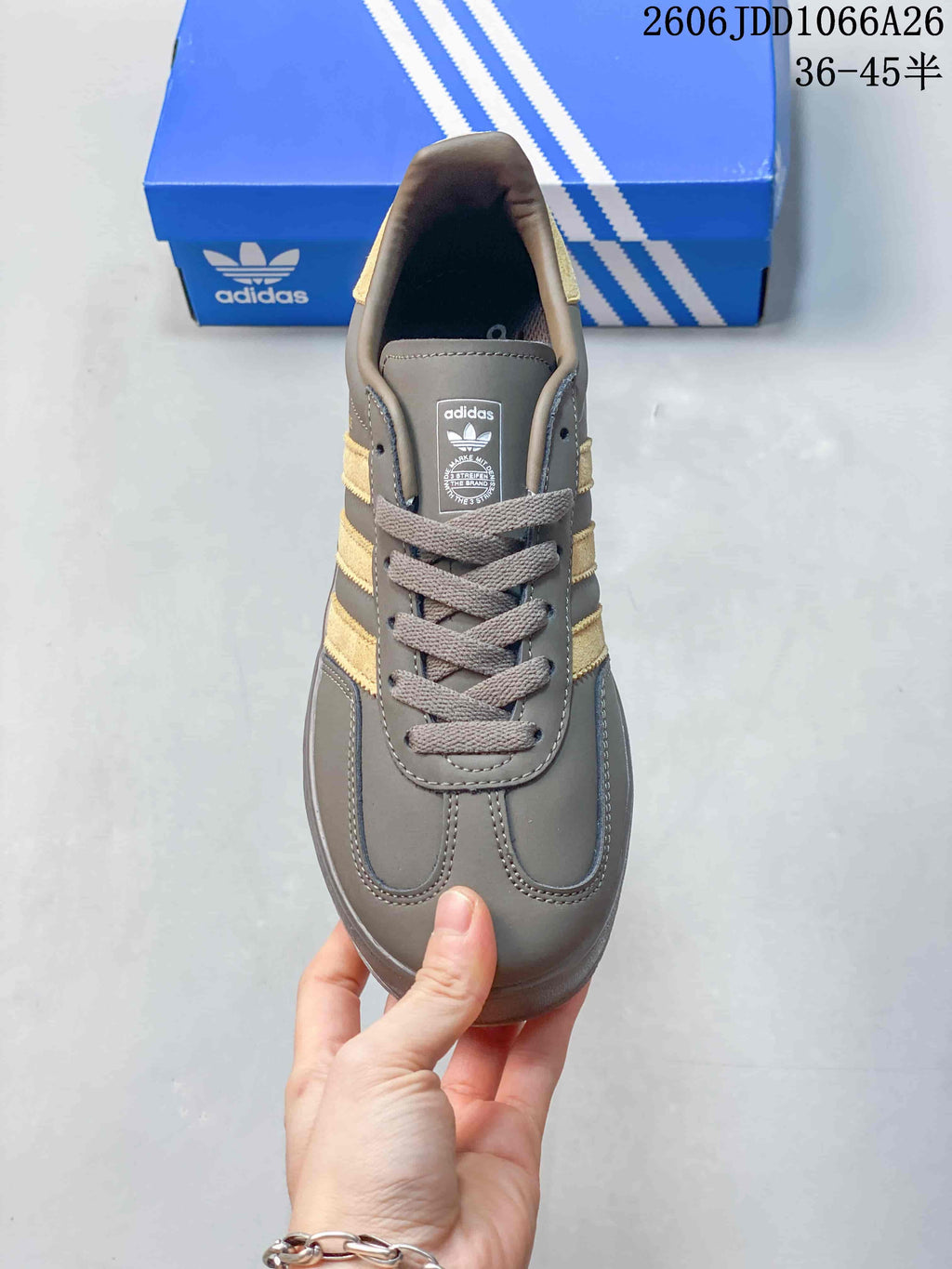 Top view showing the rounded toe, gray laces, tongue label, and gold-toned side stripes.