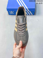 Top view showing the rounded toe, gray laces, tongue label, and gold-toned side stripes.