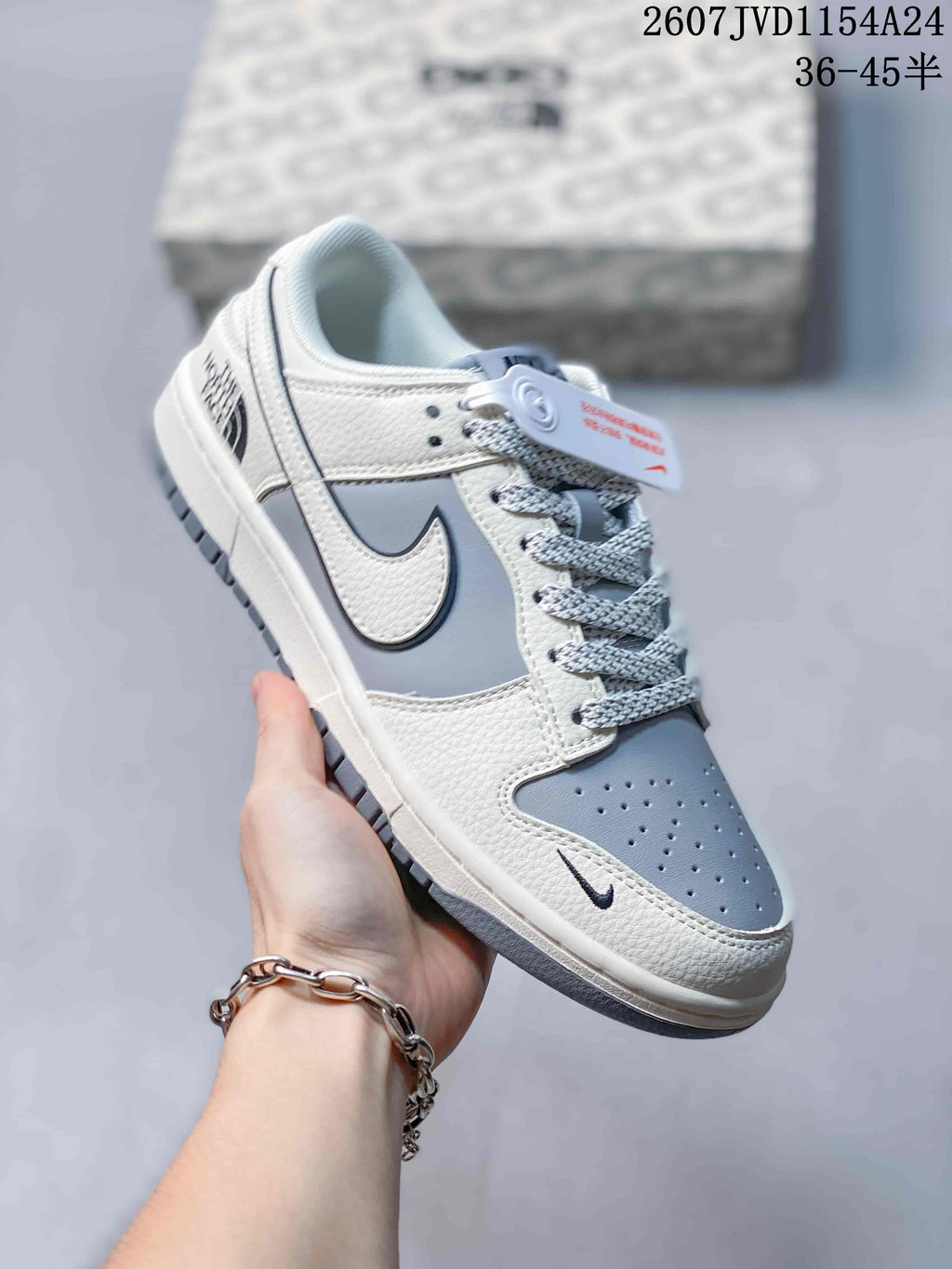 Angled close-up showing the grey and white upper, side Swoosh, patterned laces and low-top construction.