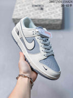 Angled close-up showing the grey and white upper, side Swoosh, patterned laces and low-top construction.