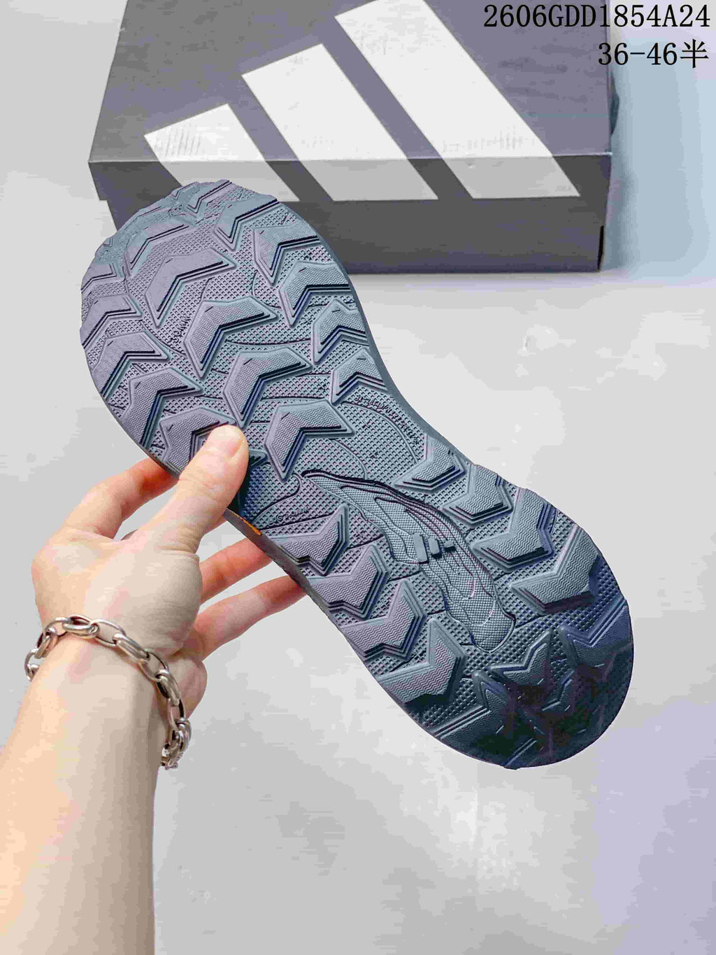 Close-up of the patterned outsole of a dark gray trail running shoe