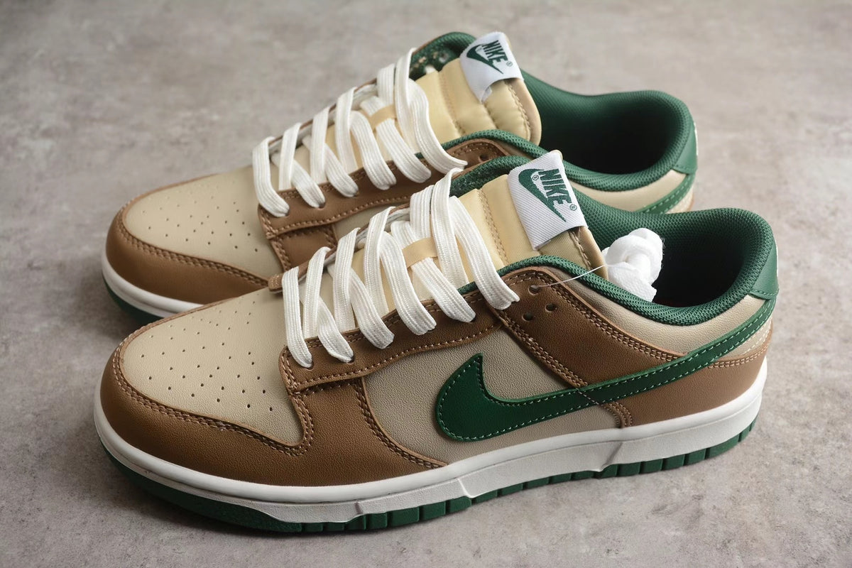 Angled pair view showing the low-top silhouette, cream and brown upper, green Swoosh, white laces, and green outsole.