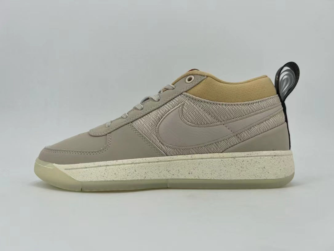 Side view of cream and beige Nike low-top sneakers with textured panels and a speckled midsole